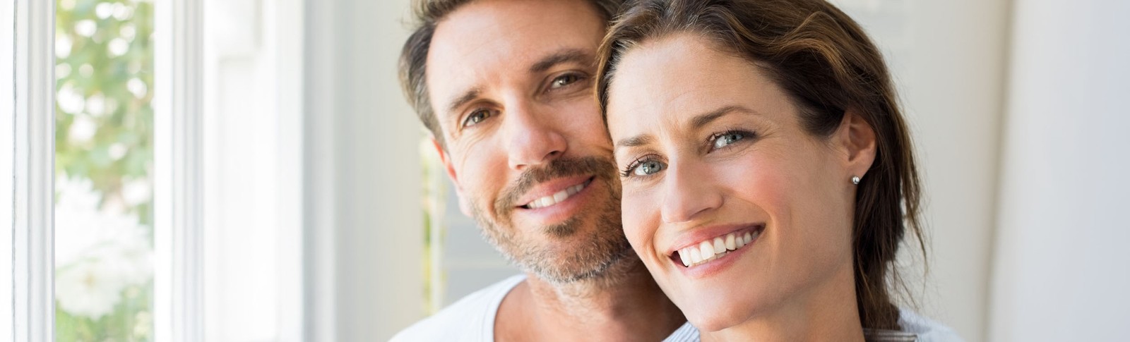 Paar lächelt zufrieden in die Kamera - nach einer erfolgreichen Augenlidstraffung in den Moser Kliniken